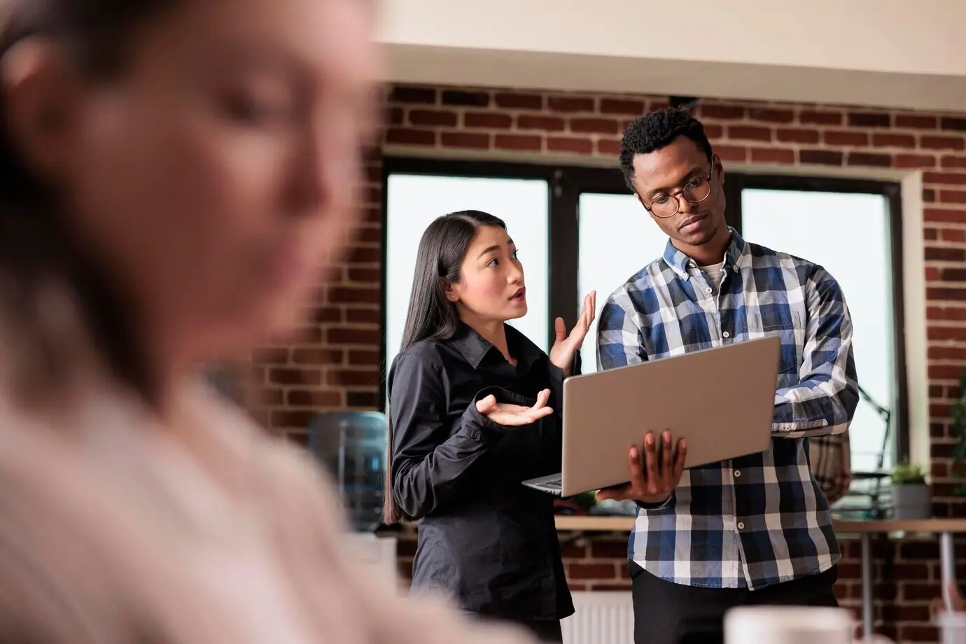 Softwareentwickler analysieren empfangene verschlüsselte Dateien, indem sie sie auf Schadsoftware scannen. Mitarbeiter einer Cybersicherheitsbehörde nutzen einen Laptop, um die Internetbandbreite und den von der Datenbank genutzten Speicherplatz zu überwachen.